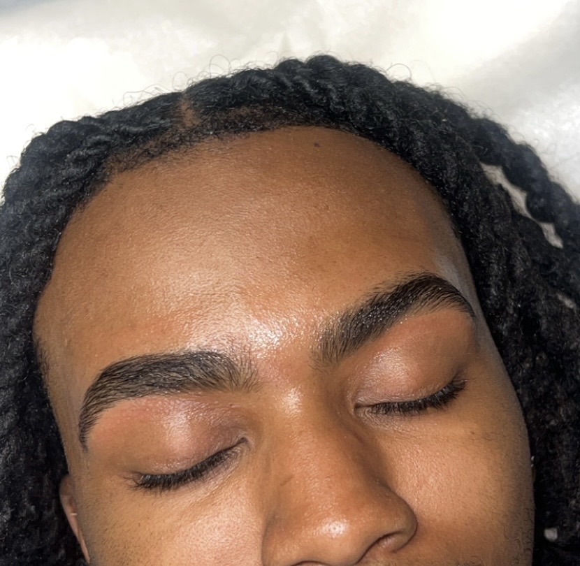 Close-up of a person's face with closed eyes and well-groomed eyebrows.