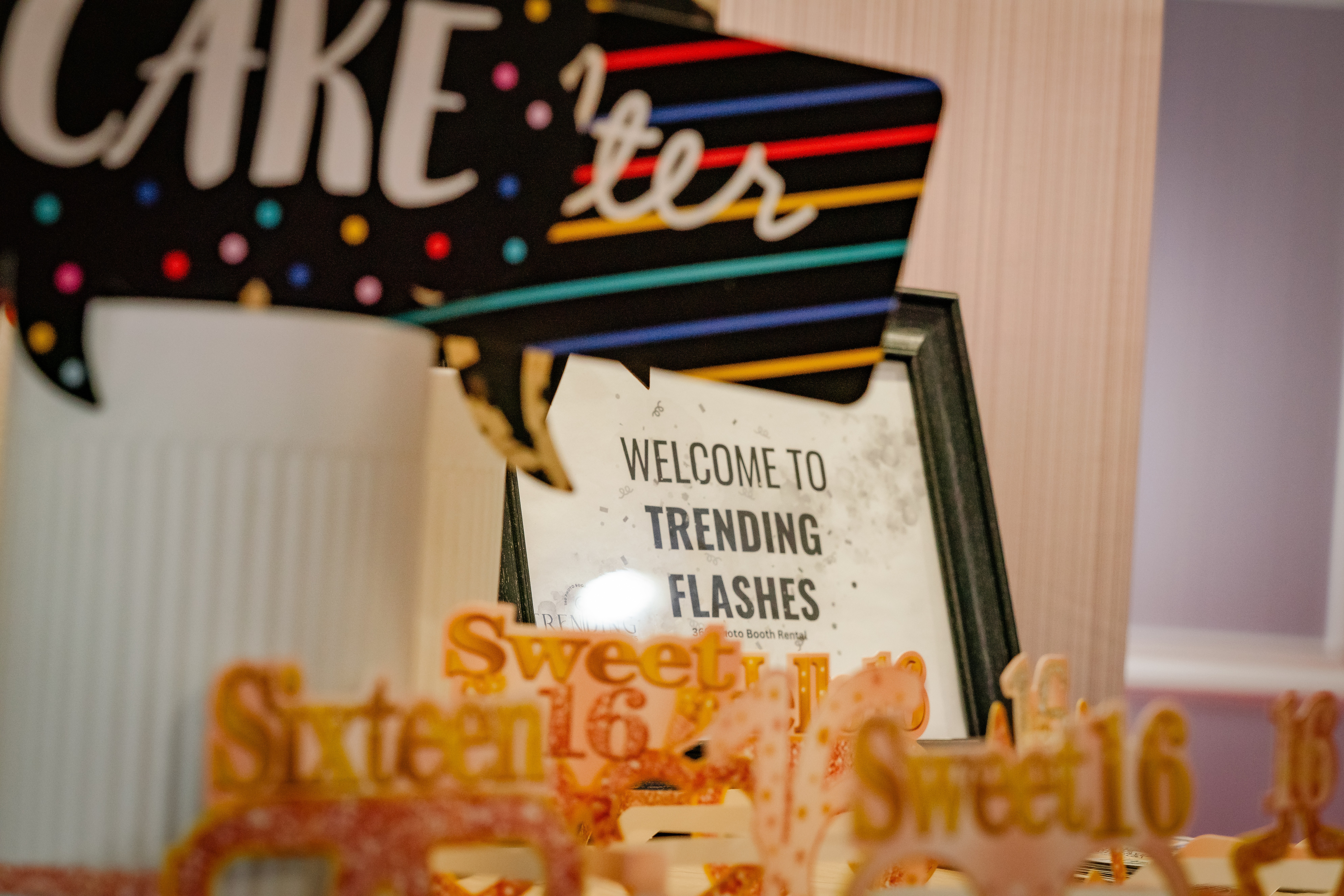 Decorative cake with colorful lettering and a framed sign reading 