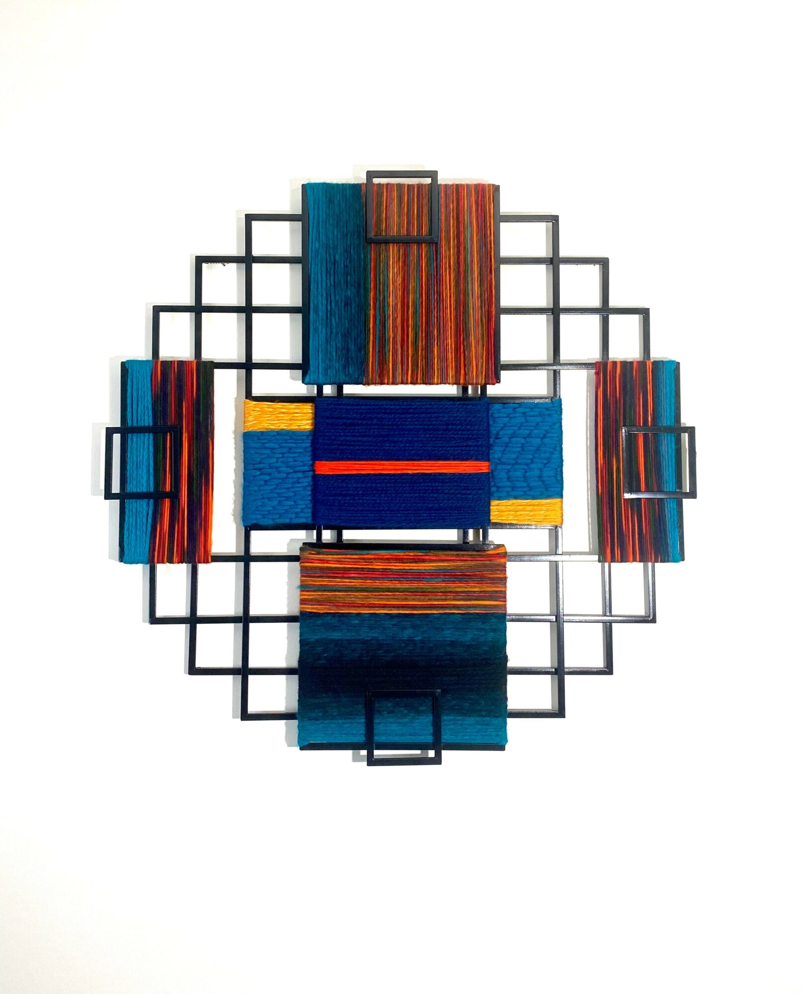 Decorative wall art with geometric metal grid and colorful wooden blocks arranged in a symmetrical pattern.