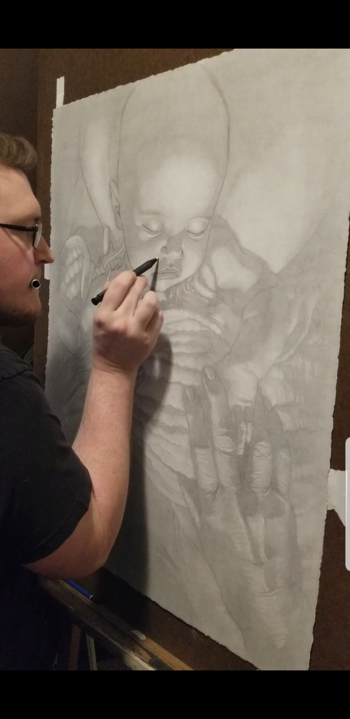 Artist drawing a detailed pencil sketch of a person on large paper, with a focus on the face and upper body.