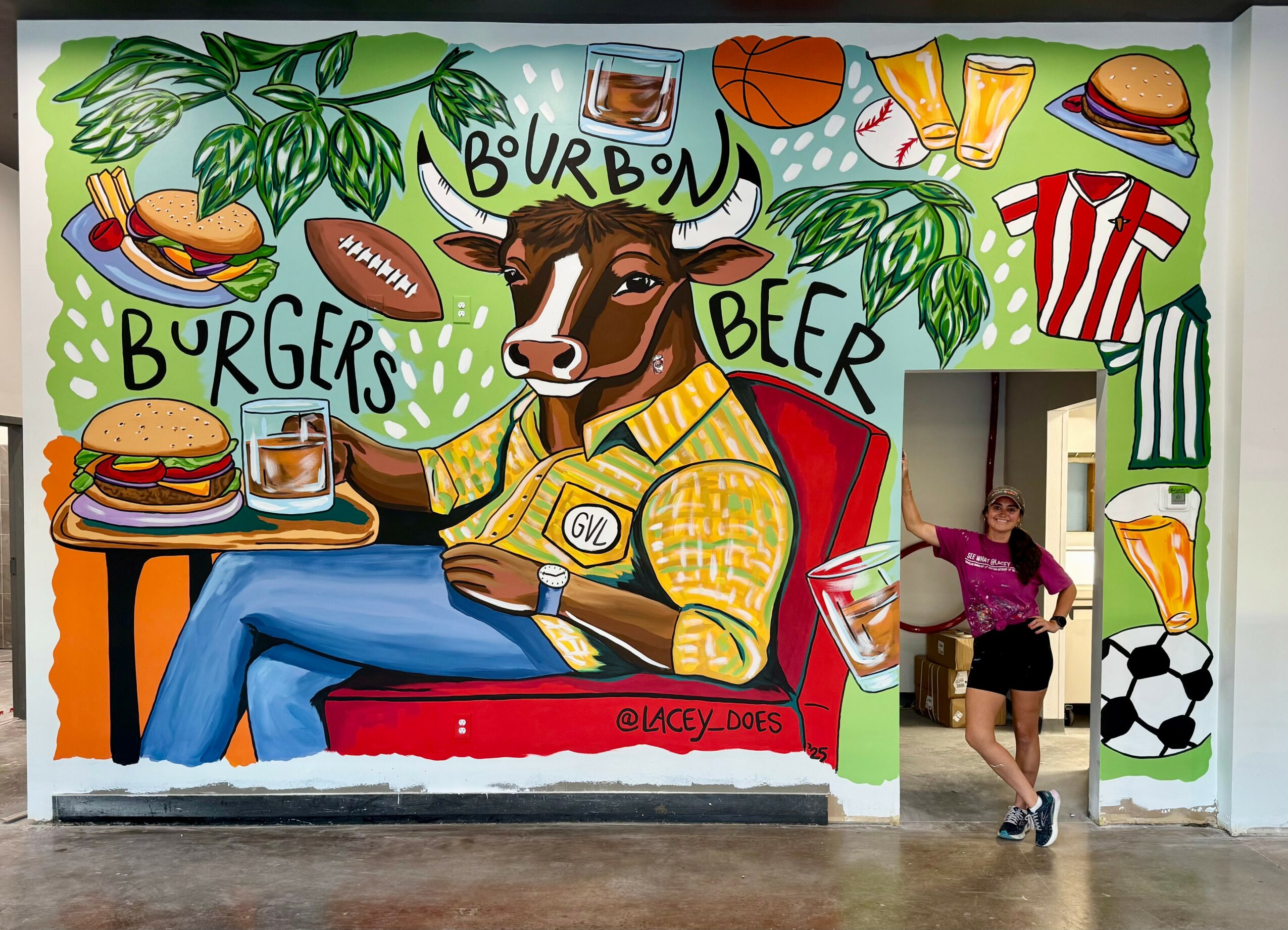 Colorful mural of a cow with a beer, burger, and sports items, with a person standing nearby. Bright, lively scene.