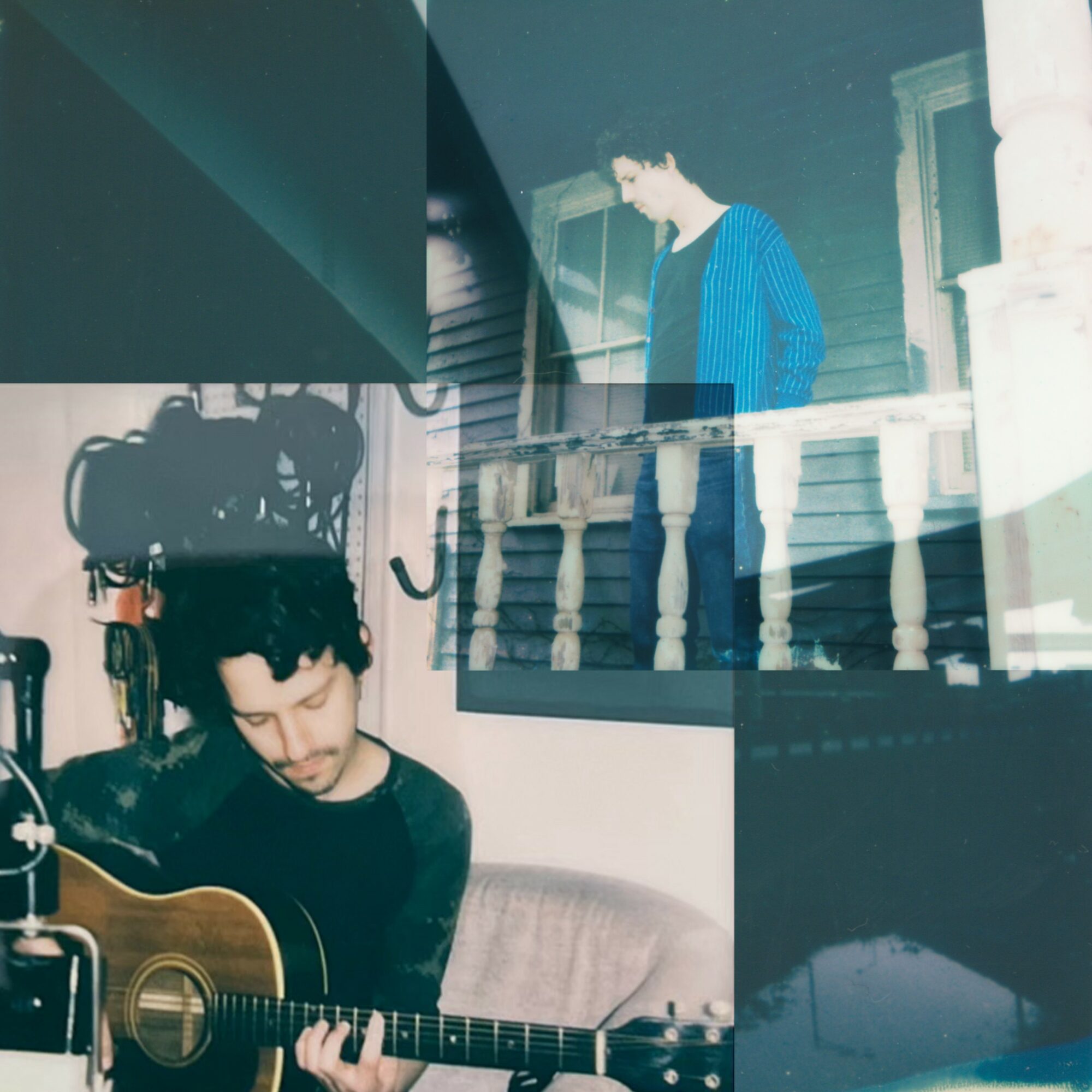 Young man playing guitar indoors, with a reflection of a person on a balcony in the window behind him.