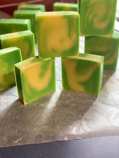 Several green and yellow marbled soap bars arranged on a surface, some standing upright and others lying down.