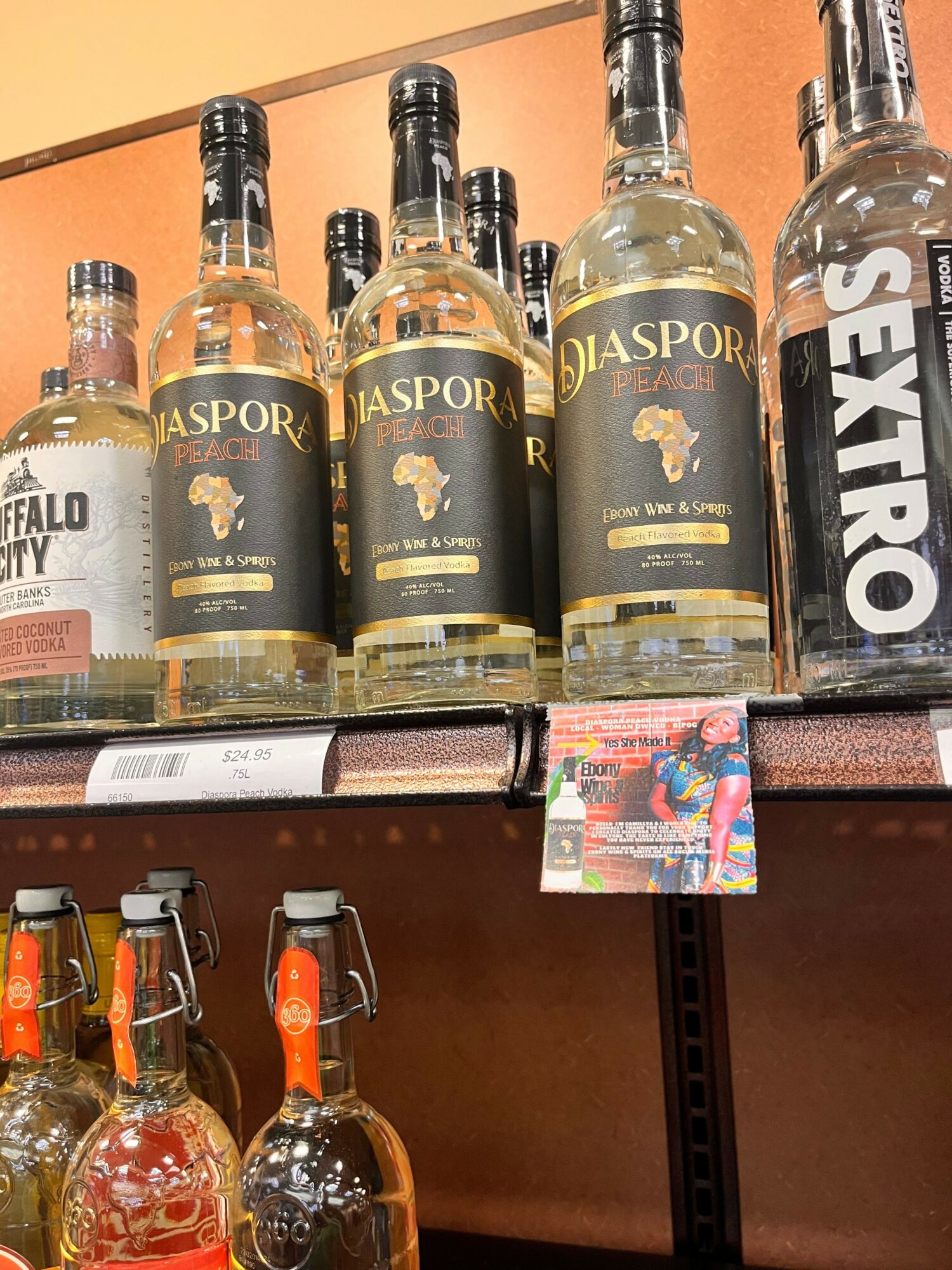 Shelf with bottles of alcohol, a small colorful card, and a brown box, with a brown background.