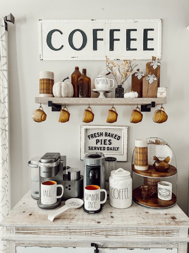 Coffee shop display with mugs, baked goods, and a sign reading 'Coffee' on a wooden table.