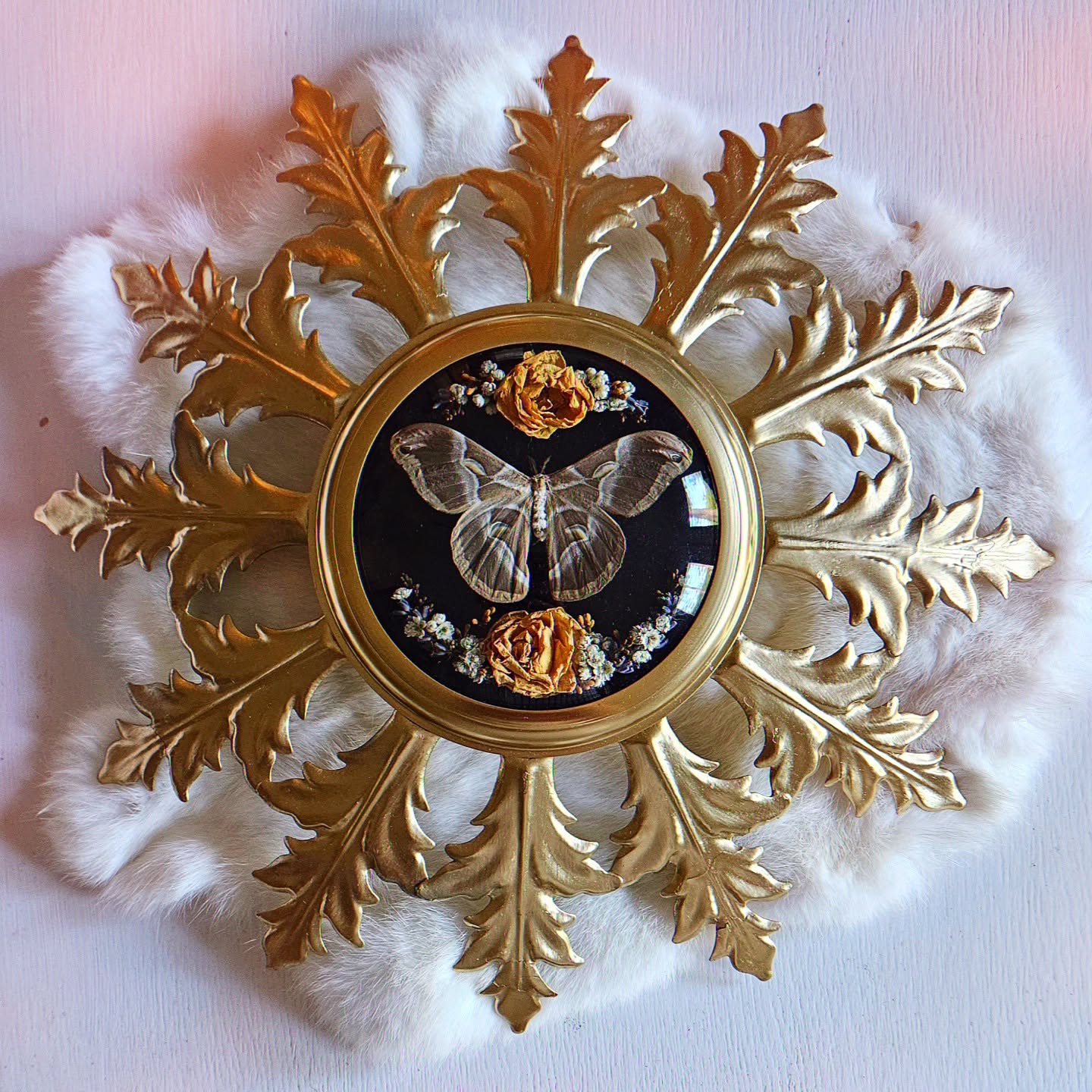 Decorative wall clock with a butterfly and floral design, surrounded by gold leaf-shaped ornaments and white fluffy accents.