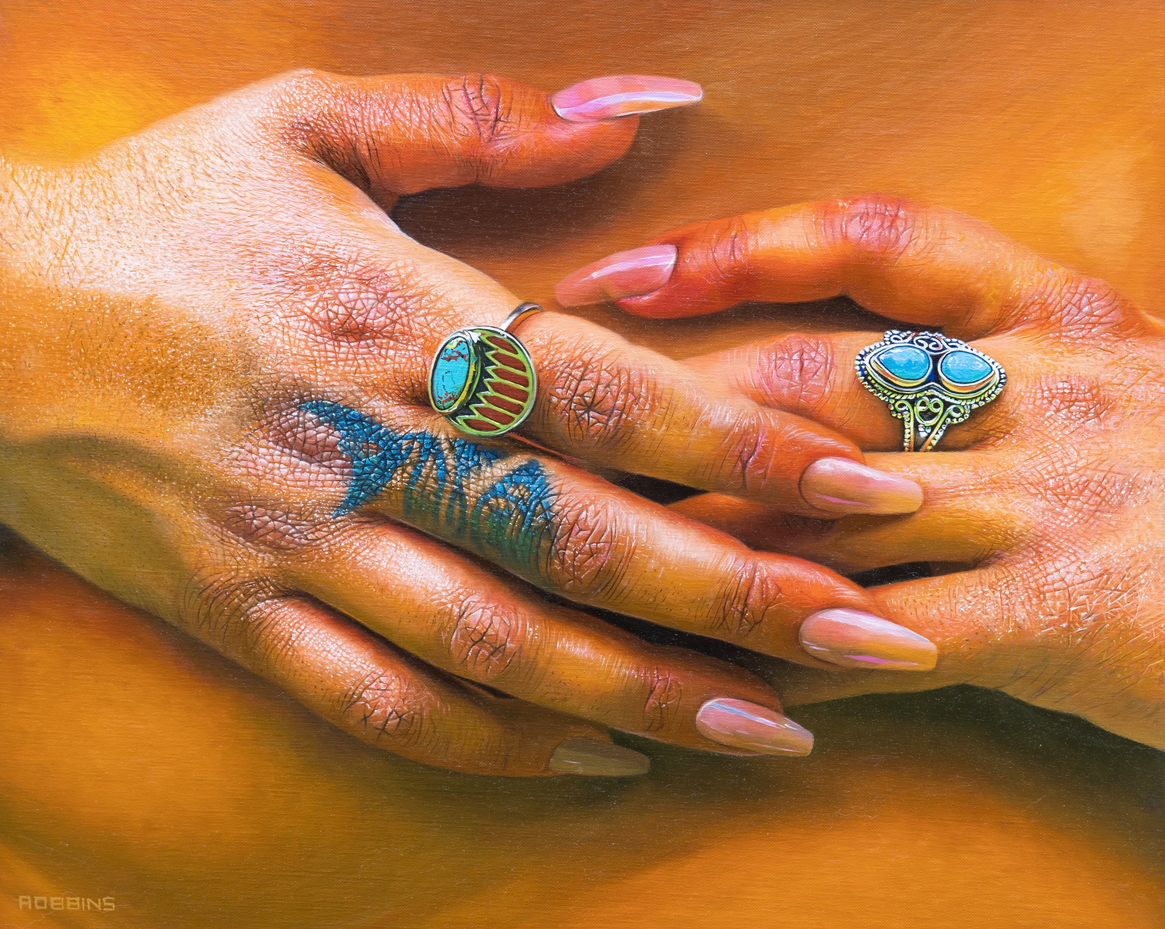 Two hands with rings, one hand has a blue tattoo, and both have long, manicured nails.