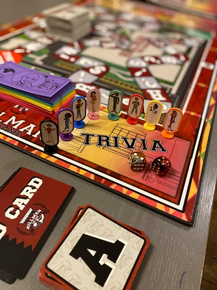 Board game with colorful pieces, cards, and dice on a table, focusing on a trivia section with game pieces and dice.