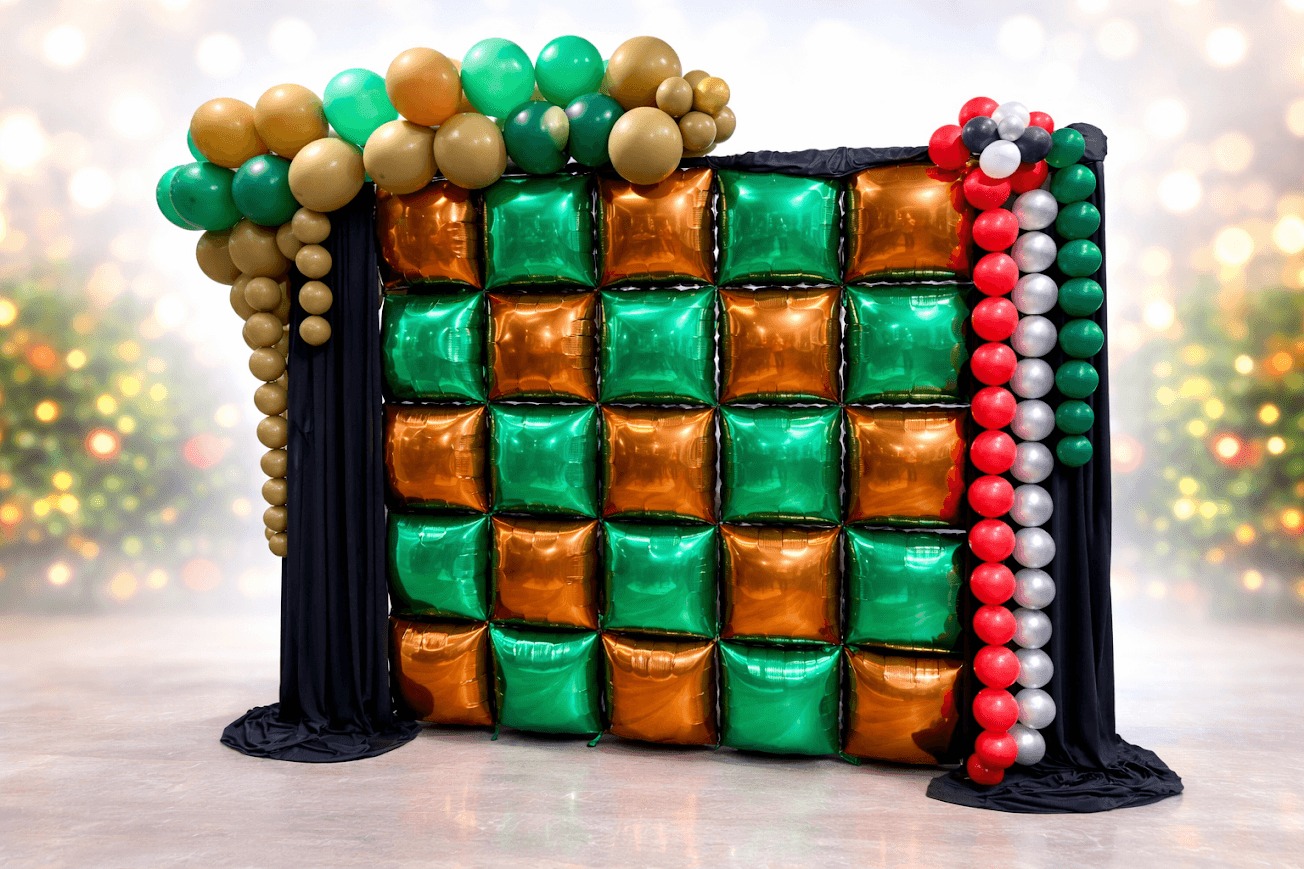 Decorated chocolate and candy wall with balloons, set against a festive background with blurred lights.